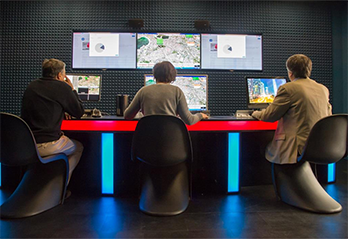 Group of people sitting around screens